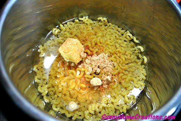 Instant Pot with noodles, butter, water and cajun seasoning in it